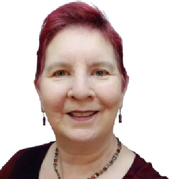 Sue Wilhite, smiling, with short magenta hair, drop earrings, and a beaded necklace